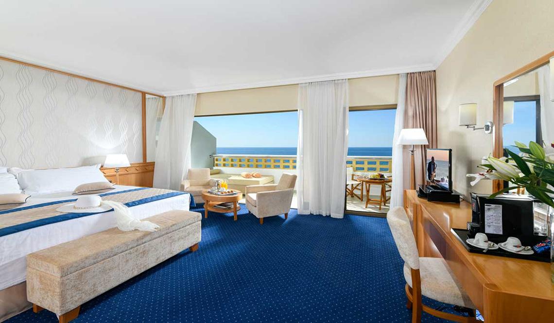 Hotelzimmer des Athena Royal Beach Hotel mit Meerblick, modernen Möbeln und Annehmlichkeiten.