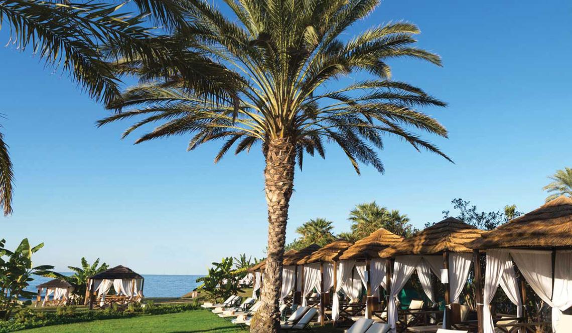 Reihe von Sonnenliegen am Strand des Athena Royal Beach Hotels.