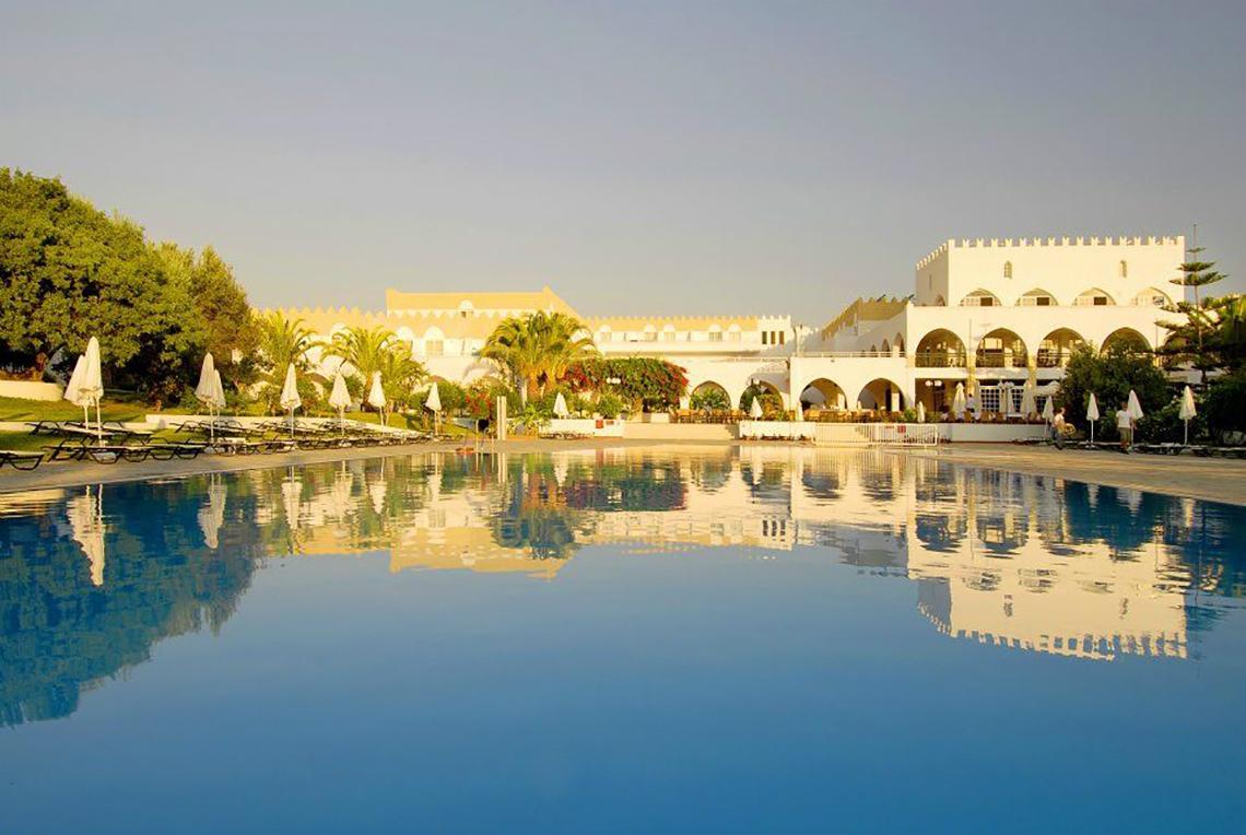 Außenbereich des Platanista Hotels mit Pool und Liegestühlen unter Sonnenschirmen.
