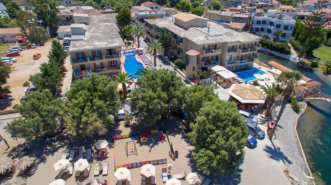 Luftaufnahme des Kalyves Beach Hotels mit Swimmingpool und umliegenden Gebäuden und Bäumen.