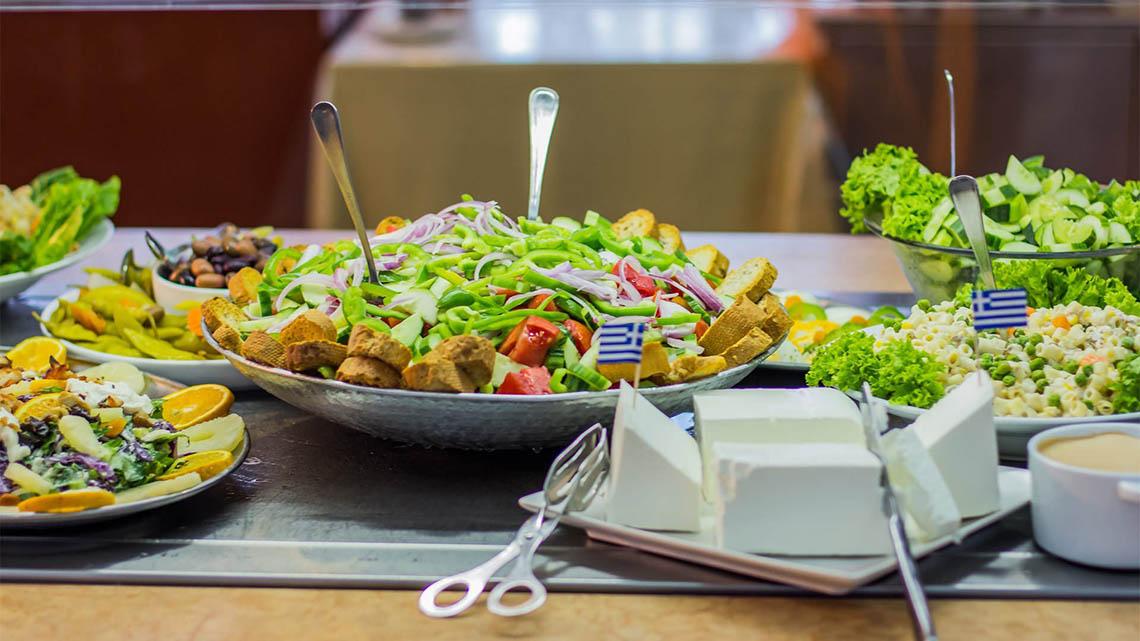 Ein Buffettisch im Kalyves Beach Hotel mit verschiedenen Salaten, Brot und Dips.