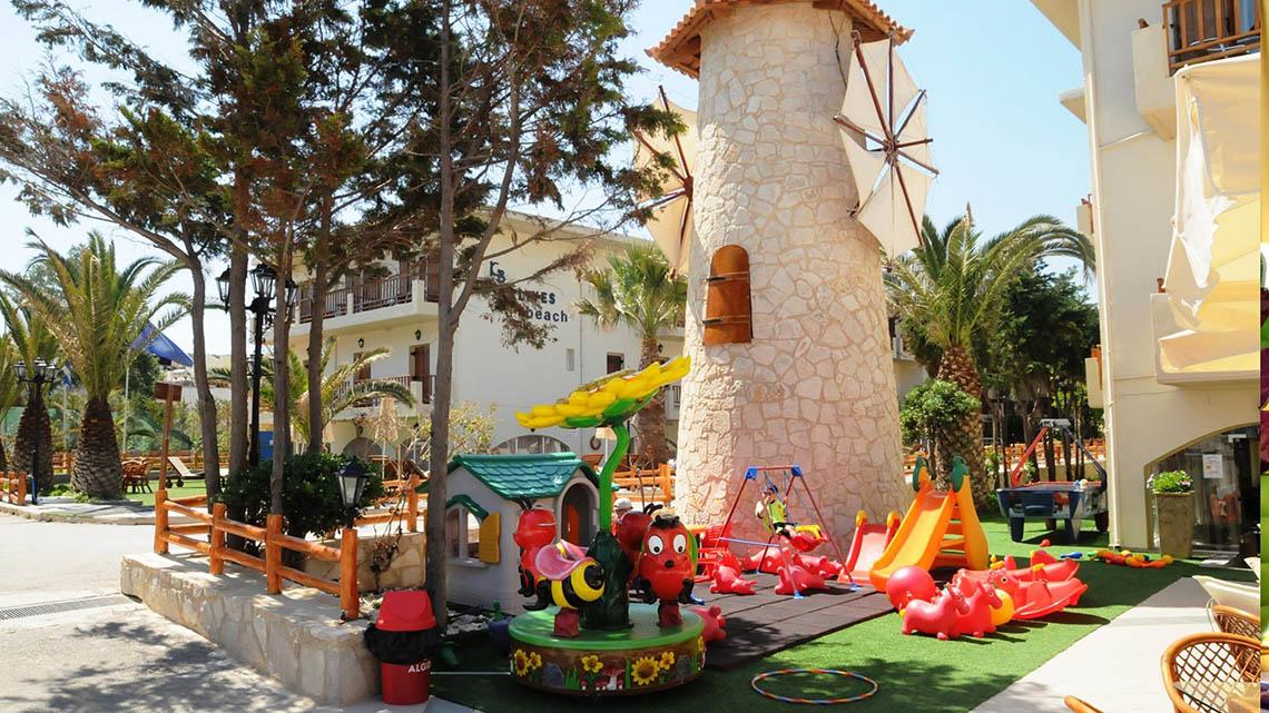 Ein Kinderspielplatz vor dem Kalyves Beach Hotel mit einer Mühle und vielen Spielgeräten.