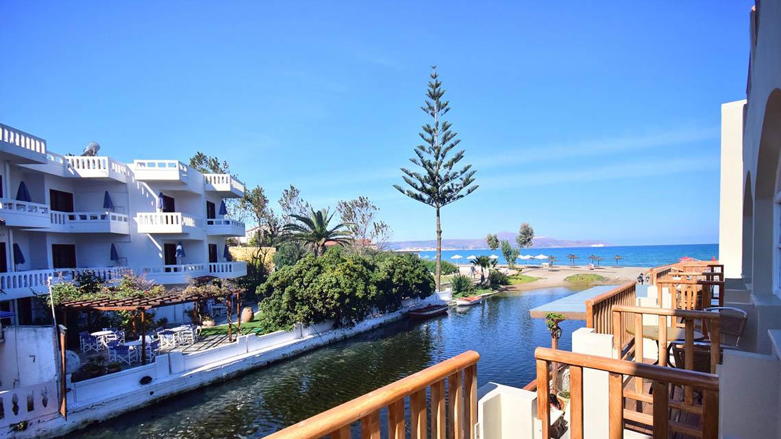 Aussicht vom Balkon des Kalyves Beach Hotels auf eine Bucht und eine Straße.
