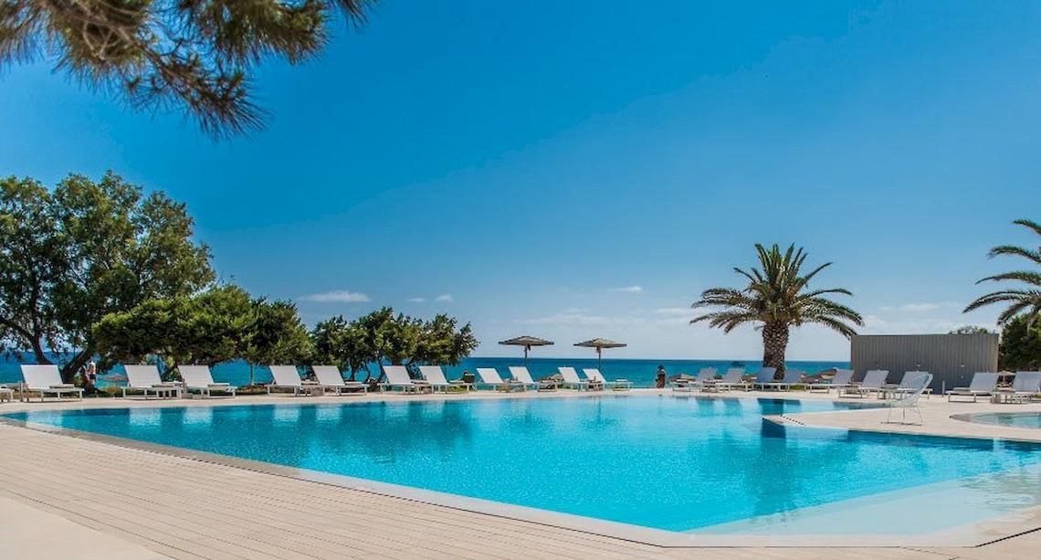 Außenpoolbereich des Bay Hotel mit Liegestühlen und Sonnenschirmen am Strand