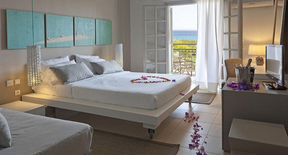 Schlafzimmer im The Bay Hotel & Suites mit Meerblick, Bett mit Blumendekor, Balkon und Meersicht