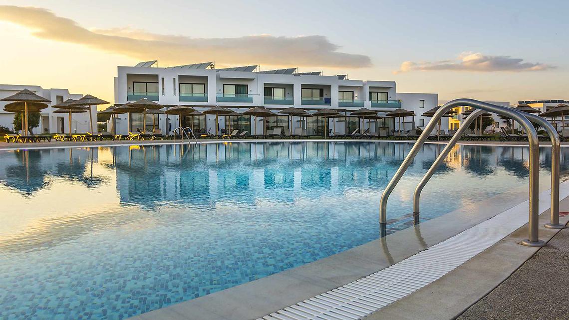 Außenpool des Club Plimmiri Hotels mit Lounge-Stühlen und Sonnenschirmen