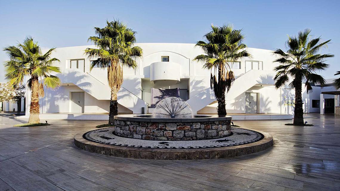 Eingang des Club Plimmiri Hotels mit Brunnen und Palmen