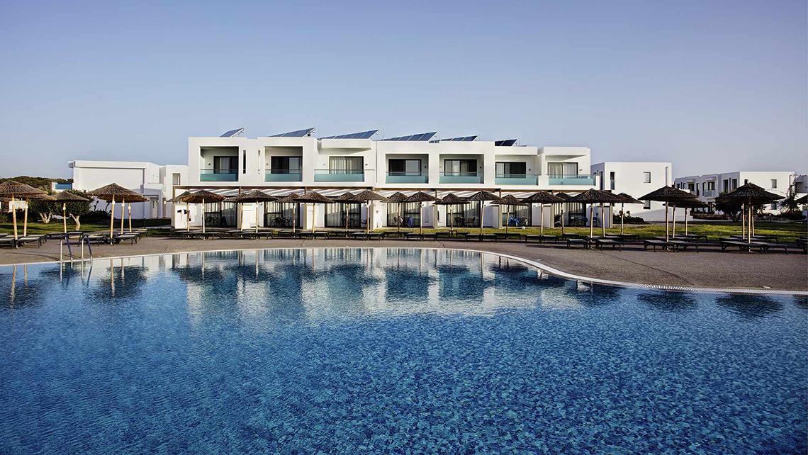 Außenansicht des Club Plimmiri Hotels mit Swimmingpool und Sonnenschirmen.