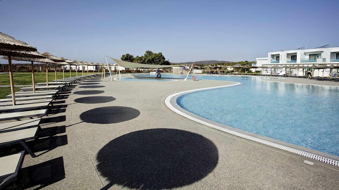 Außenpoolbereich des Club Plimmiri Hotels mit Sonnenliegen und Sonnenschirmen
