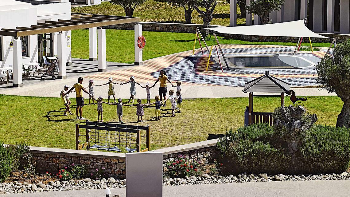 Kindergruppe spielt auf dem Spielplatz des Club Plimmiri Hotels.