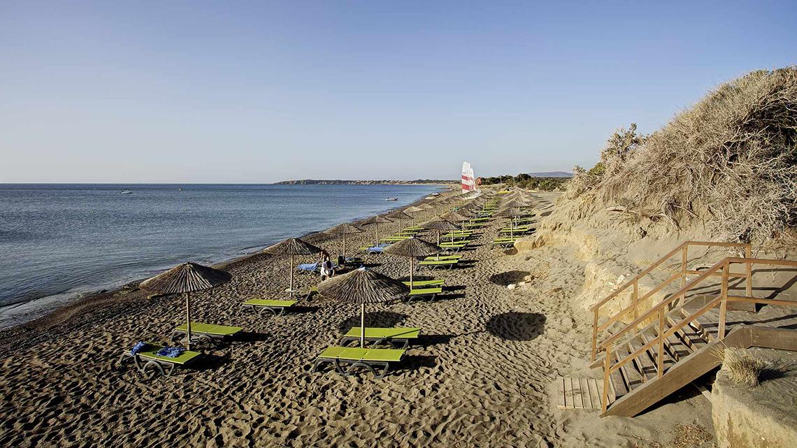 Strand mit Liegestühlen und Sonnenschirmen am Club Plimmiri Hotel