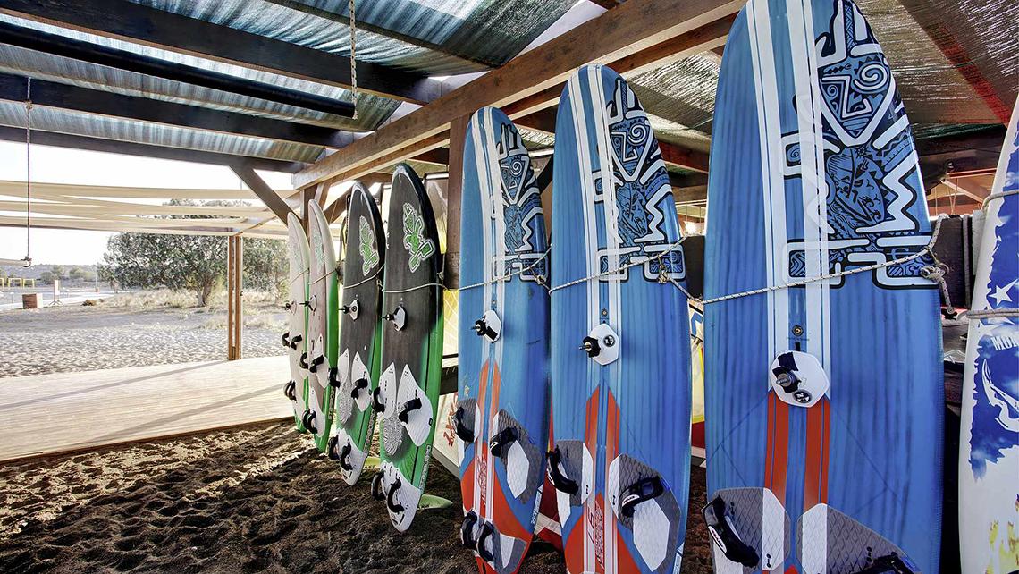 Mehrere Surfbretter mit verschiedenen Designs sind unter einem Dach ausgestellt.