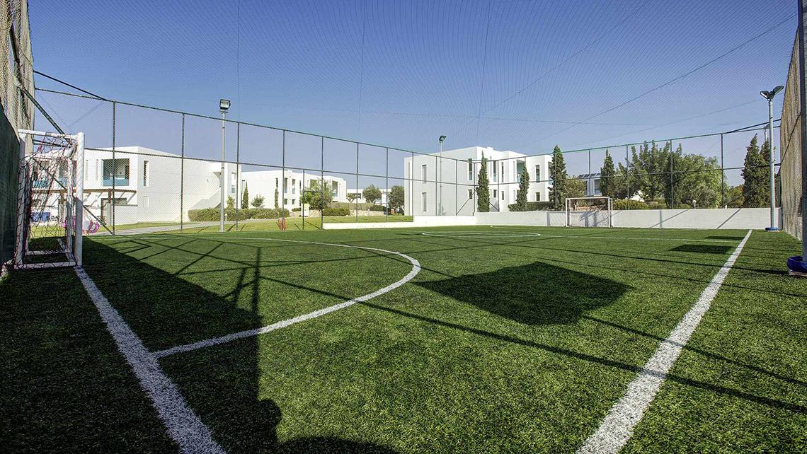Fussballplatz im Club Plimmiri Hotel mit weißem Zaun und grünem Rasen