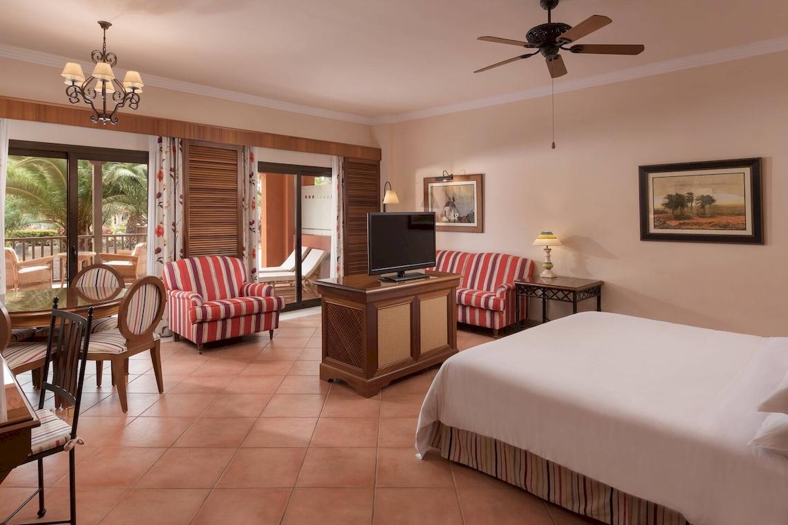 Hotelzimmer im Sheraton Fuerteventura Beach, Golf & Spa Resort mit Bett, Fernseher und Tisch.