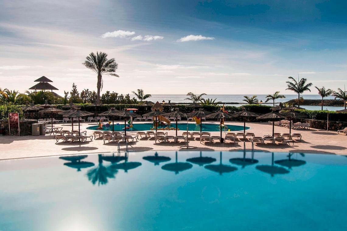 Außenpool mit Liegestühlen und Sonnenschirmen im Sheraton Fuerteventura Beach, Golf & Spa Resort.