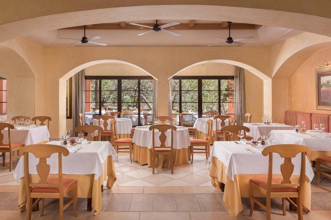 Innenansicht des Restaurants im Sheraton Fuerteventura Beach, Golf & Spa Resort mit gedeckten Tischen und Stühlen.