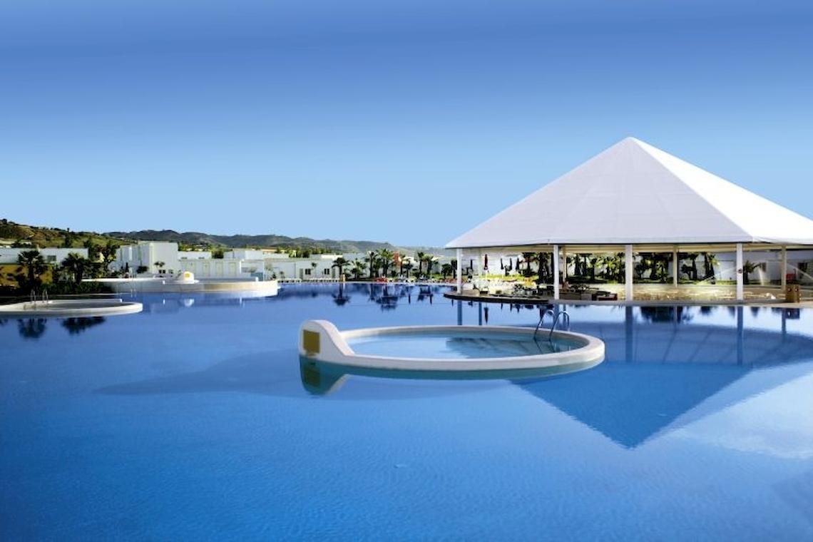 Außenpool des Club Esse Sunbeach Village Hotels mit weißen Gebäuden und Palmen