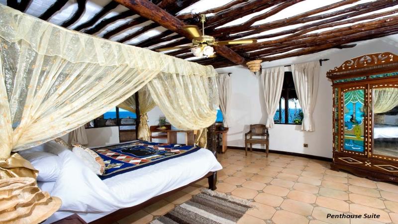 Schlafzimmer im Sands at Chale Island Resort mit Himmelbett, Holzdecke und Meerblick.