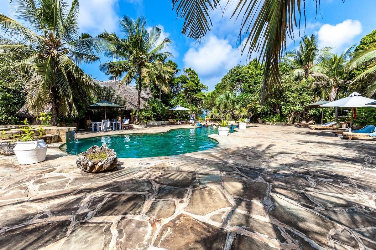 Poolbereich mit Sonnenschirmen und Pflanzen im Sands at Chale Island Resort