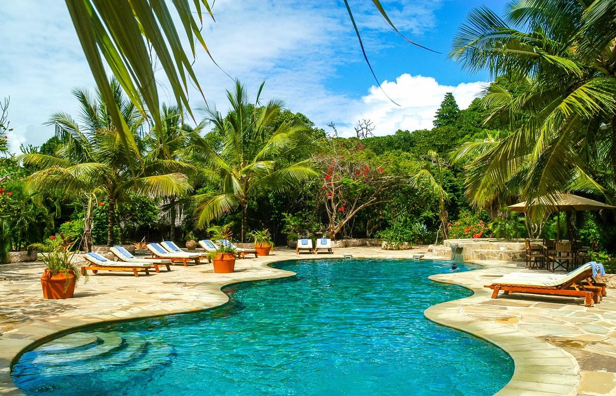 Pool-Lounge-Bereich im Sands at Chale Island Resort mit Sonnenliegen und Pflanzen