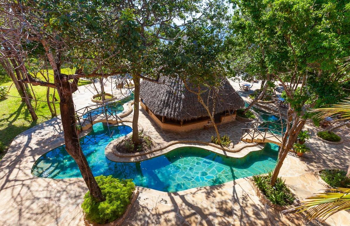 Luftaufnahme des Sands at Chale Island Resorts mit Swimmingpools und Hütten.