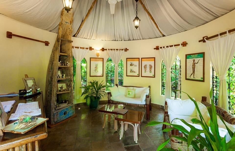 Innenansicht des Sands at Chale Island Resort mit weißen Möbeln und Pflanzen.