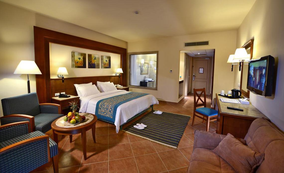 Charmillion Club Aqua Park Hotelzimmer mit Bett, Tisch, Fernseher und Möbeln