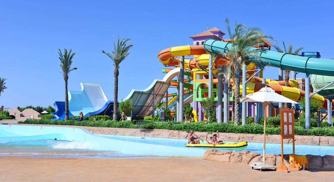 Foto des Charmillion Club Aqua Park mit mehreren bunten Wasserrutschen und einem Schwimmbecken.