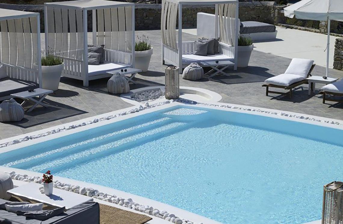 Pool mit weißen Lounge-Bereichen im Rocabella Mykonos Art Hotel & Spa