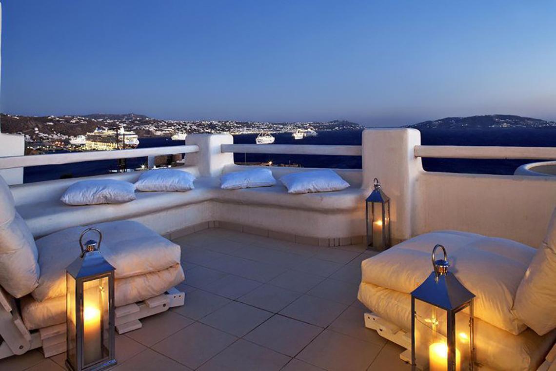 Terrasse des Rocabella Mykonos Art Hotel & Spa mit Blick auf den Hafen und das Meer bei Nacht