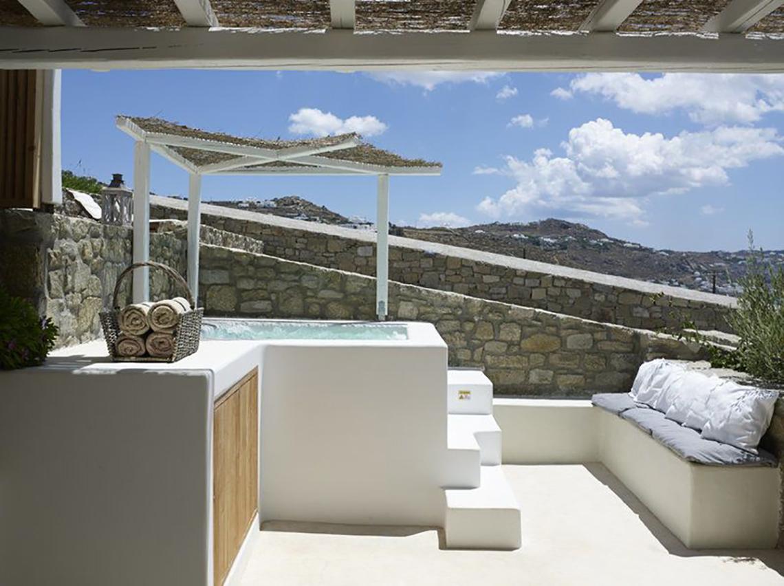 Außenbereich des Rocabella Mykonos Art Hotel & Spa mit Whirlpool unter einem Pavillon.