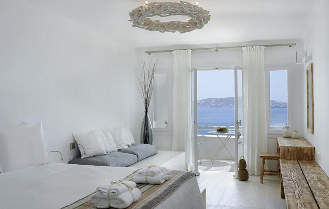 Schlafzimmer im Rocabella Mykonos Art Hotel mit Blick auf das Meer.