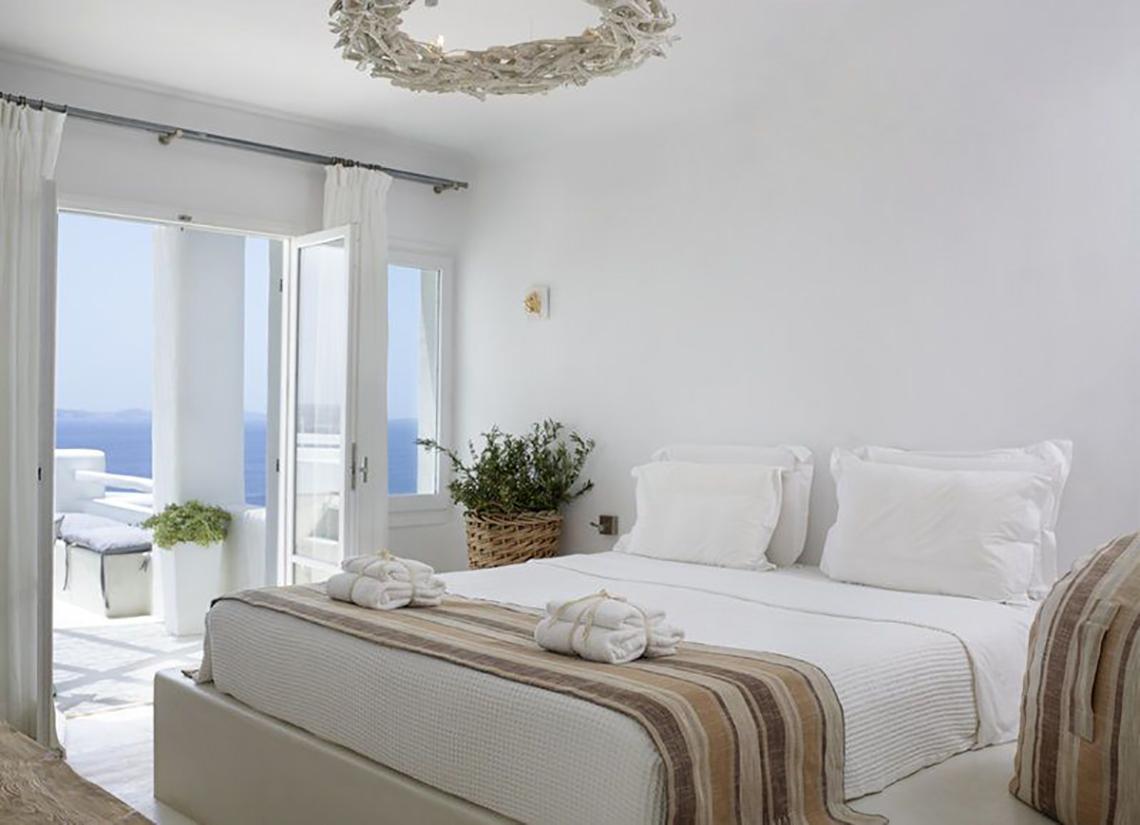 Schlafzimmer im Rocabella Mykonos Art Hotel mit Blick auf das Meer.