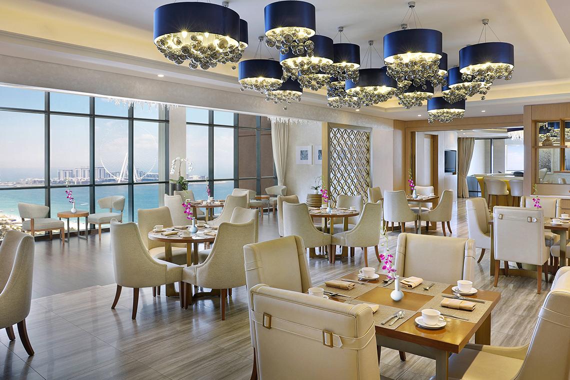 Innenansicht des Restaurants im Habtoor Grand Resort & Spa mit Blick auf das Meer.