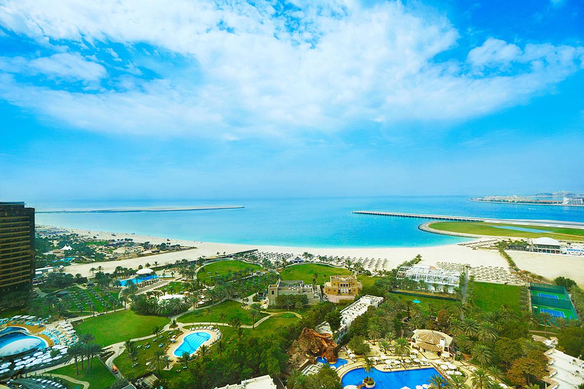 Luftaufnahme des Habtoor Grand Resort & Spa mit Strand, Pools und Gebäuden