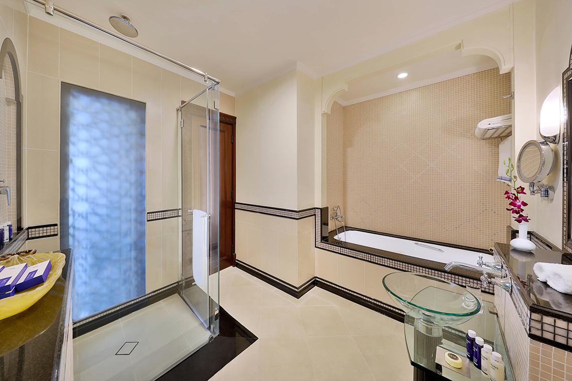 Eleganter Badezimmerbereich im Habtoor Grand Resort & Spa mit Badewanne und separater Dusche.