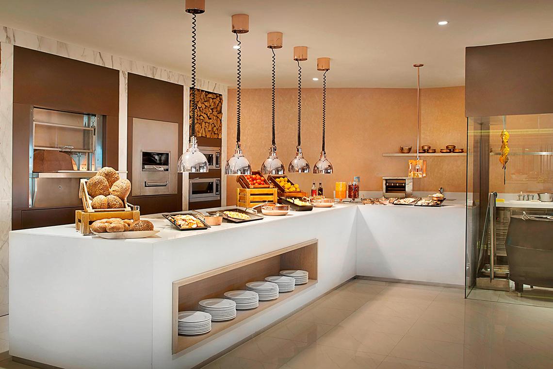 Buffettisch im Habtoor Grand Resort & Spa mit verschiedenen Gerichten und Utensilien.