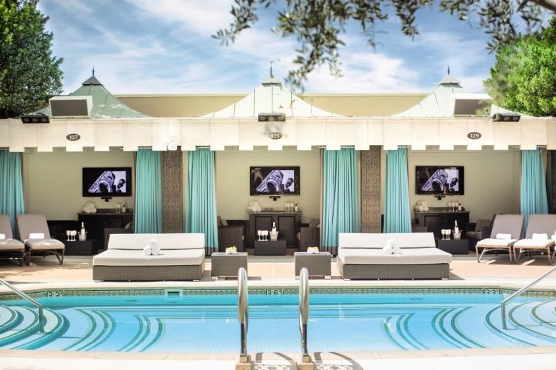 Pool-Loungebereich im Venetian Resort Hotel & Casino mit weißen Liegen und blauen Vorhängen.