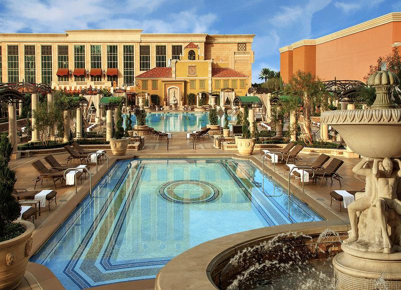 Außenpool des Venetian Resort Hotel & Casino mit Lounge-Stühlen und Brunnen.