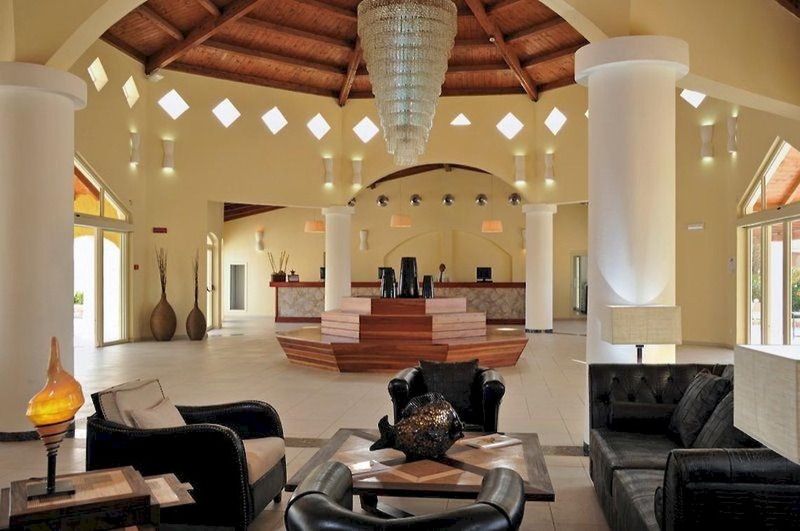 Lobby des VOI Praia De Chaves Resorts mit schwarzen Ledersofas, Holztischen und Kronleuchter.