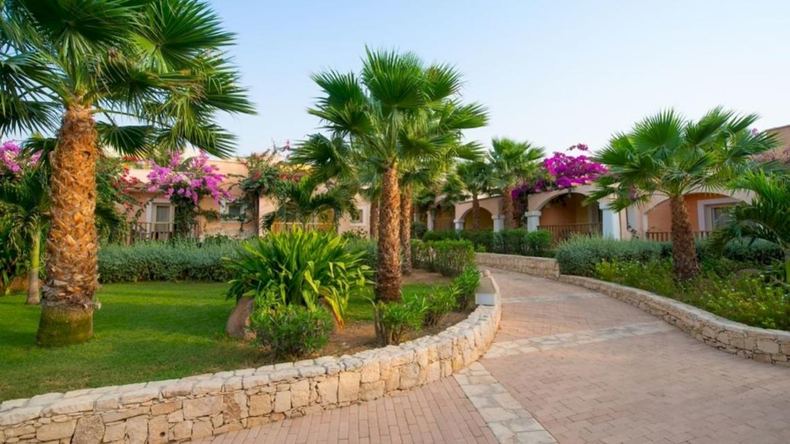 Eingang des VOI Praia De Chaves Resort mit Palmen und Gehweg.
