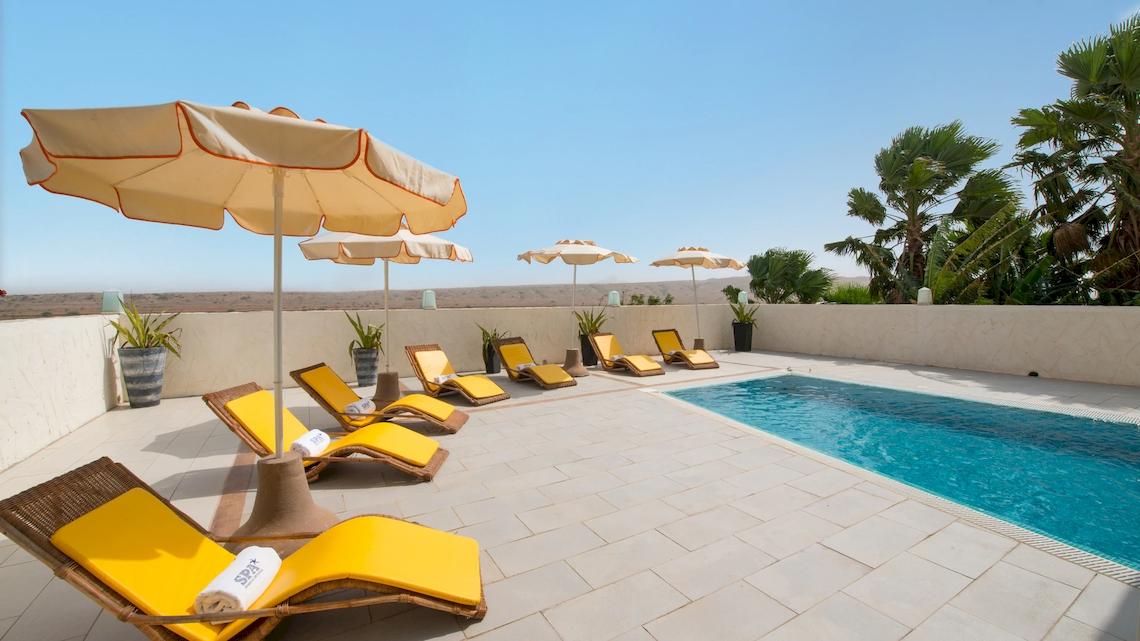 Pool-Terrasse mit Sonnenliegen und Sonnenschirmen im VOI Praia De Chaves Resort