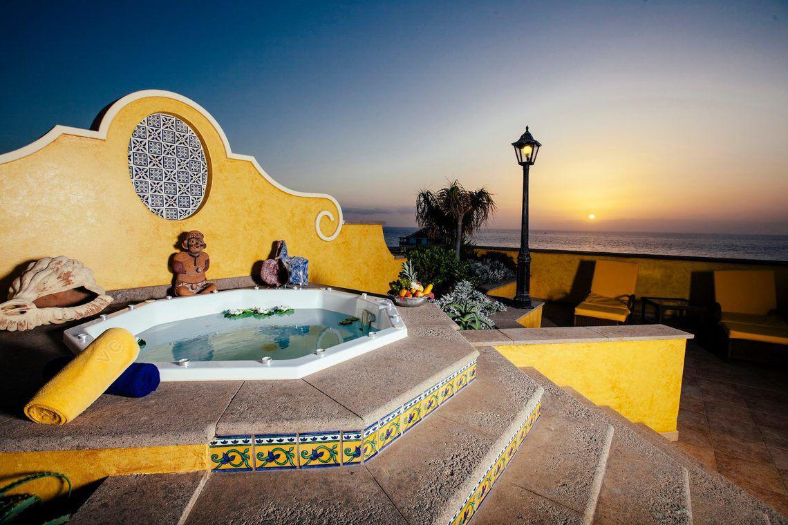 Jacuzzi auf der Terrasse der Europa Villa Cortes mit Blick auf den Ozean und Sonnenuntergang
