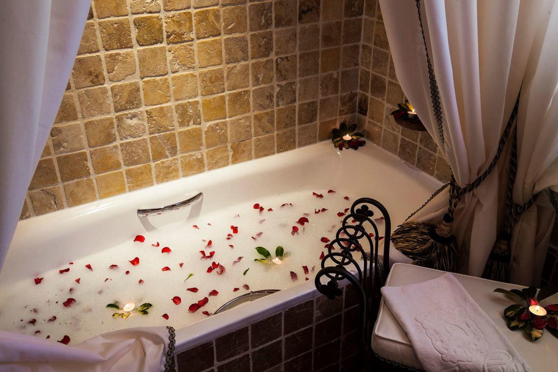 Badewanne mit Rosenblättern und Kerzen im Hotel Europe Villa Cortes.