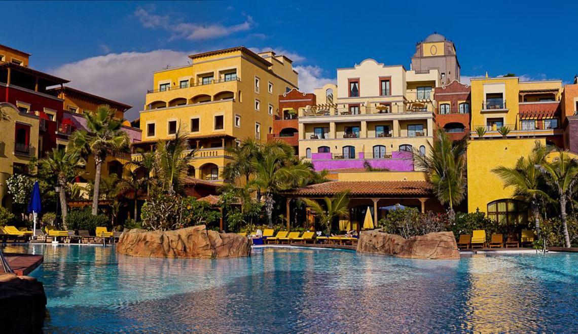 Außenbereich des Europe Villa Cortes Hotels mit Swimmingpool und Loungebereich.