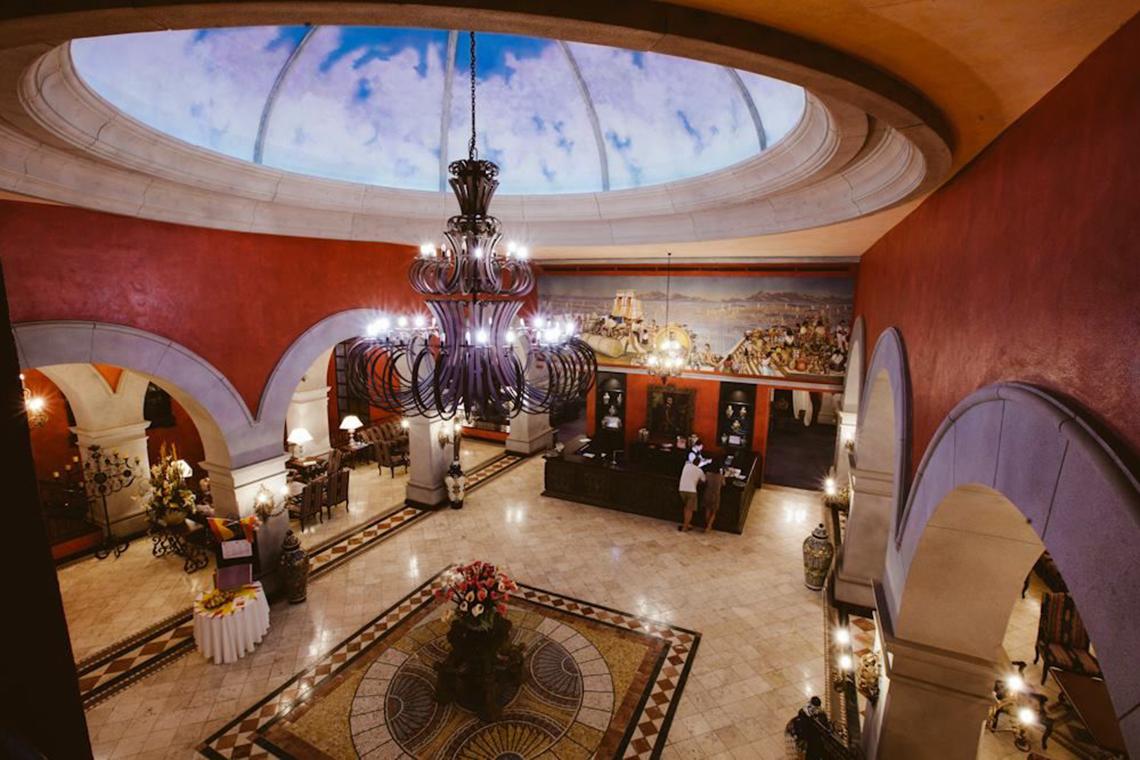 Obengesichtsansicht der Lobby des Europe Villa Cortes Hotels mit großem Kronleuchter und gemustertem Boden