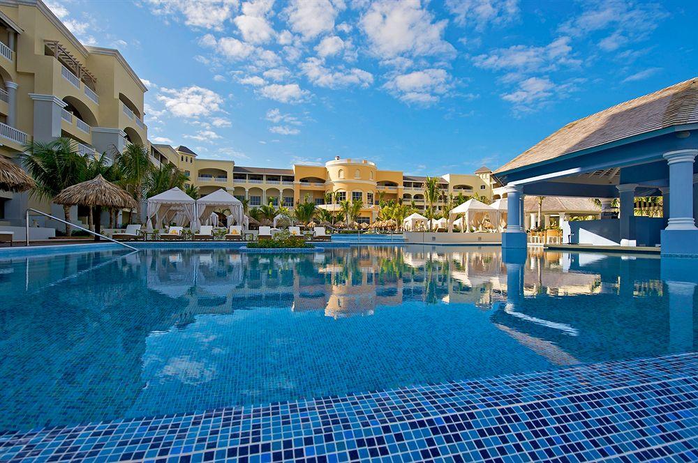 Außenpool des Iberostar Grand Rose Hall Hotels mit blauem Wasser und Gebäuden im Hintergrund