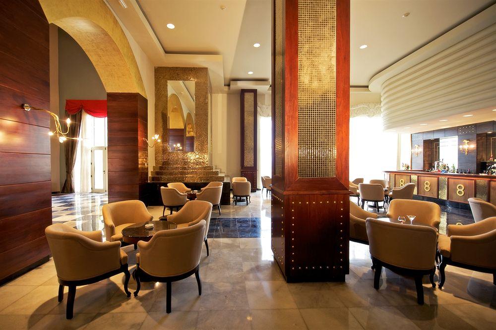 Innenansicht der Hotellobby des Iberostar Grand Rose Hall mit runden Tischen und Stühlen.