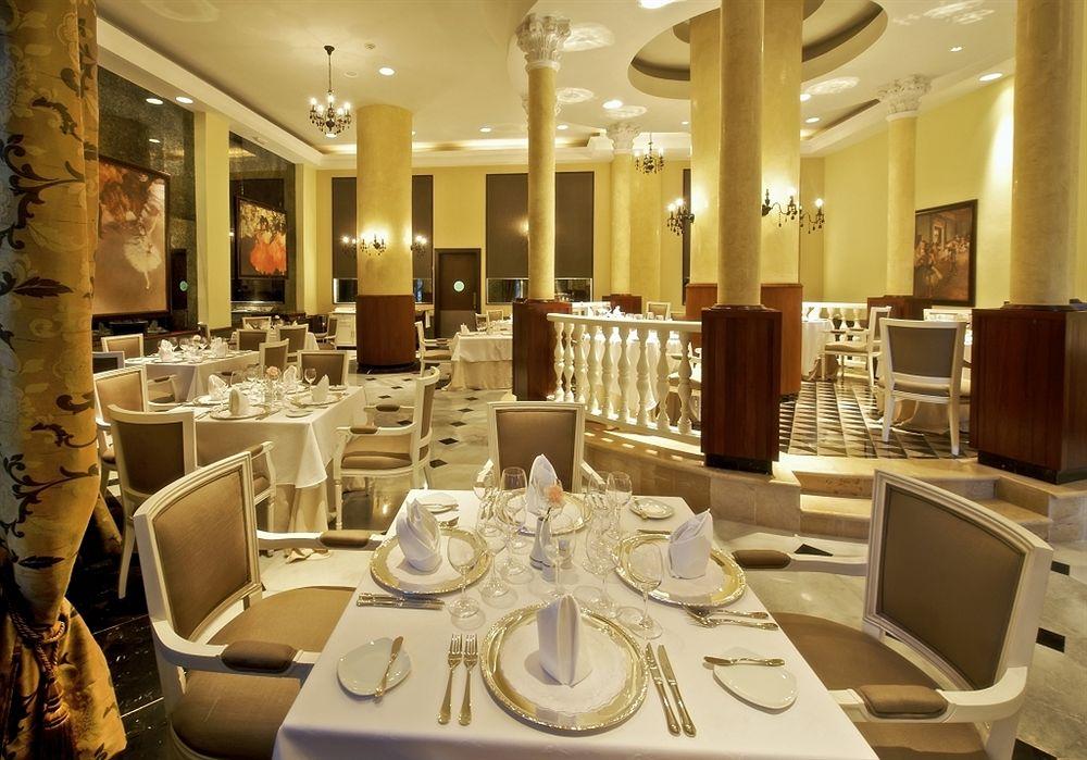 Innenansicht des Restaurants im Iberostar Grand Rose Hall Hotel mit gedeckten Tischen und eleganter Einrichtung.