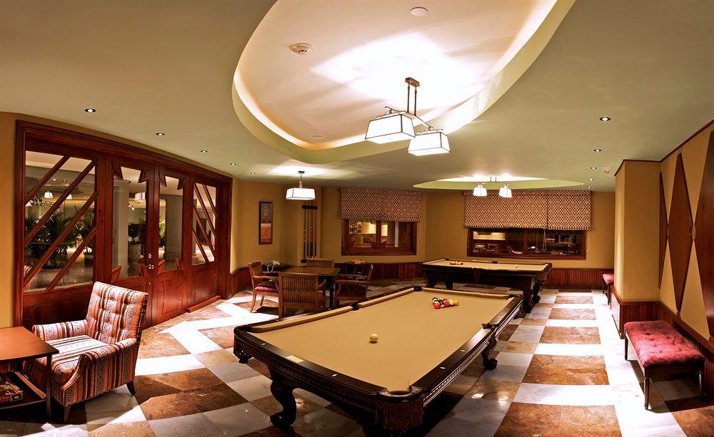 Billardraum im Hotel Iberostar Grand Rose Hall mit zwei Billardtischen und Stühlen.